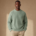 Man wearing light green ribbed drop shoulder crewneck with dark trousers