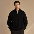 Man wearing black ribbed quarter zip jumper with dark trousers