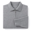 Man wearing gray quarter zip knit polo with dark trousers