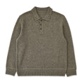 Man wearing olive knit polo shirt with dark trousers