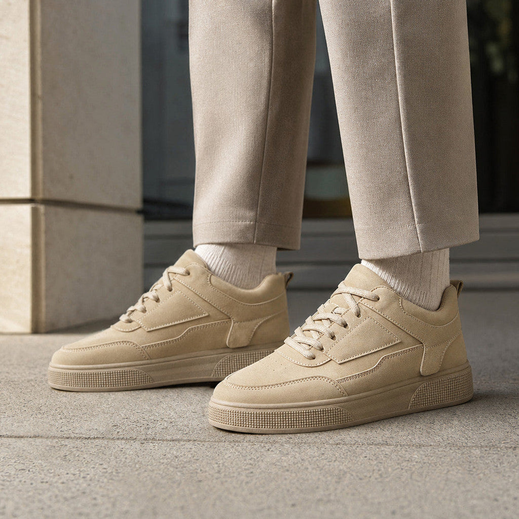 Man wearing taupe low-top trainers with tapered trousers