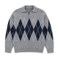 Man wearing grey argyle jumper over a shirt with dark denim