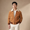 Man wearing a camel suede bomber jacket with the shearling collar turned up