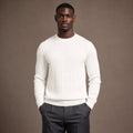 Man wearing ivory ribbed crewneck jumper with tailored trousers