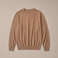 Man wearing camel crewneck jumper over a collared shirt with grey trousers