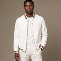 Man wearing white zip-up jacket with jeans