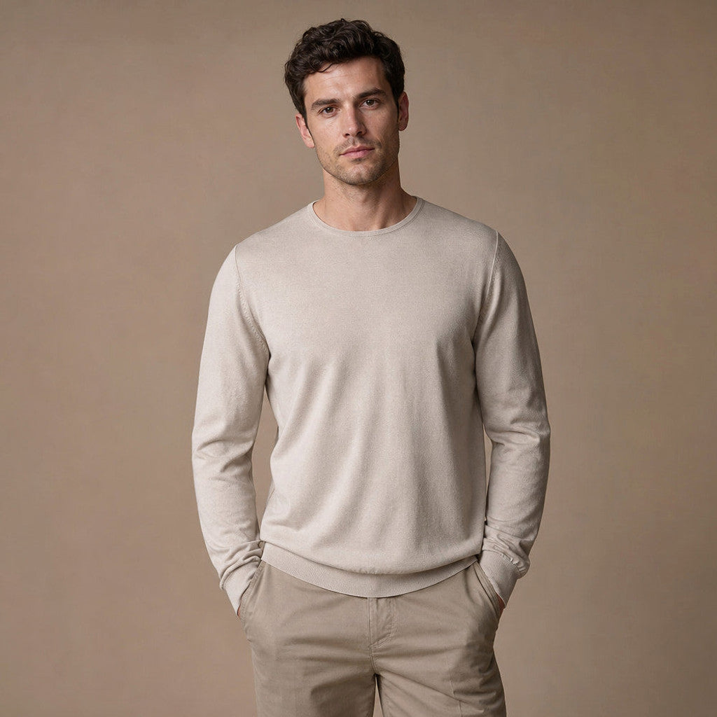 Man wearing champagne wool crewneck jumper with dark trousers
