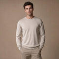 Man wearing champagne wool crewneck jumper with dark trousers