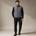 Man wearing gray sleeveless puffer vest over knitwear