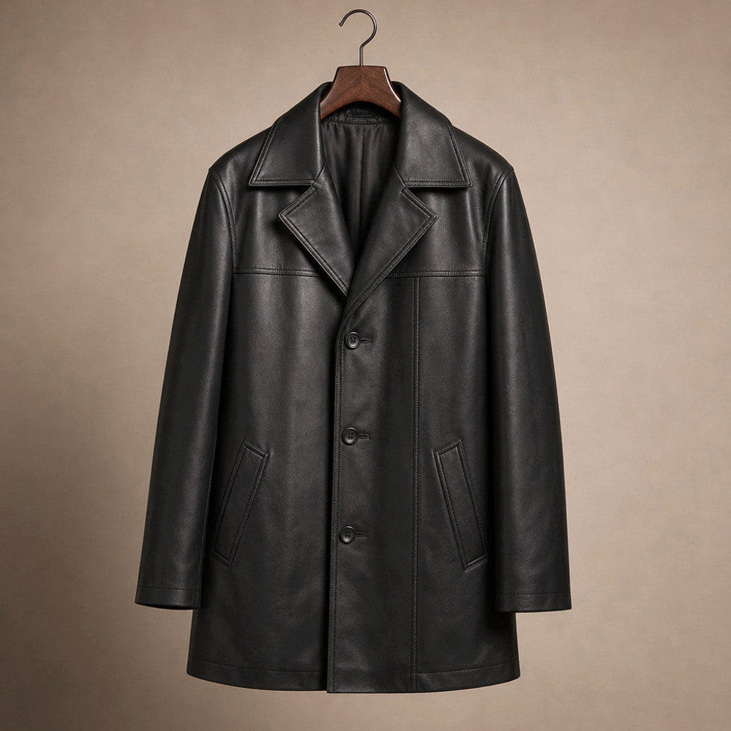 Man wearing a black leather coat buttoned over a dark suit on a city street