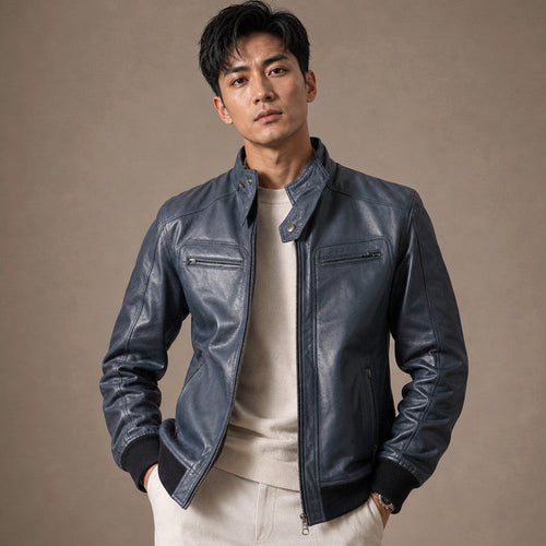 Man wearing a blue leather bomber jacket over a knit with dark denim