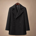 Man wearing black wool pea coat over tailoring on a winter street