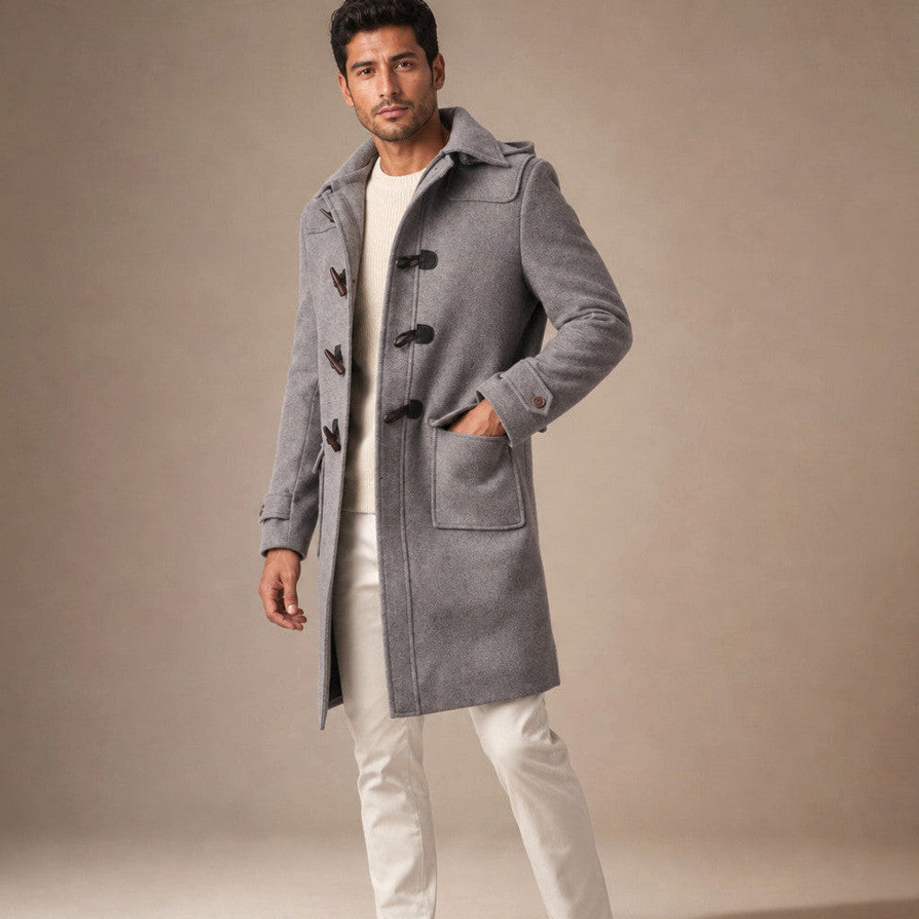 Man wearing a grey hooded duffle coat over a shirt and dark trousers