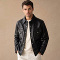 Man wearing black sheepskin trucker jacket over a tee with indigo denim