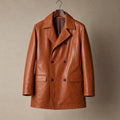 Man wearing tan brown double breasted leather trench coat with dark denim