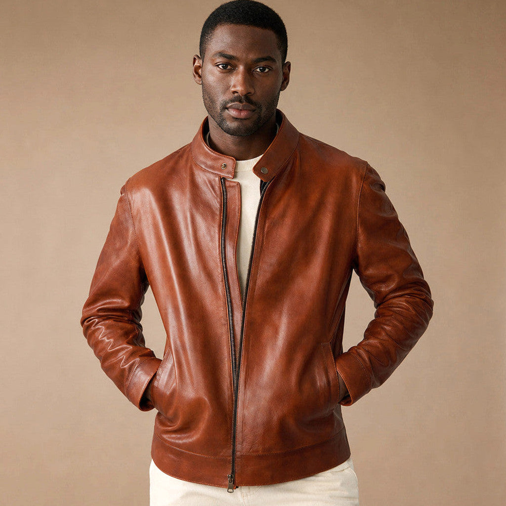 Man wearing a brown sheepskin biker jacket over a knit with dark denim