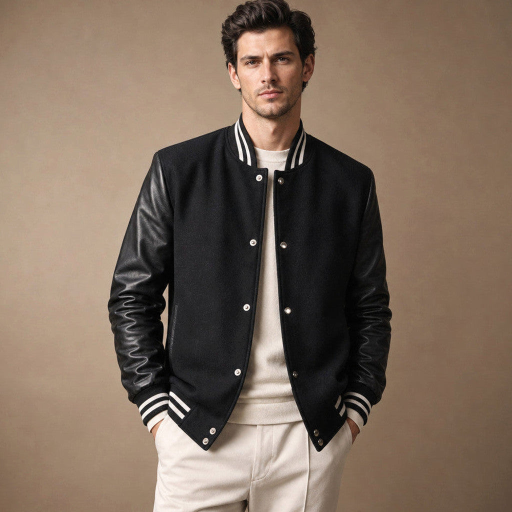 Man wearing a black varsity jacket with leather sleeves and stand collar