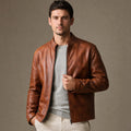 Man wearing a slim-fit chestnut brown sheepskin jacket over a dark knit