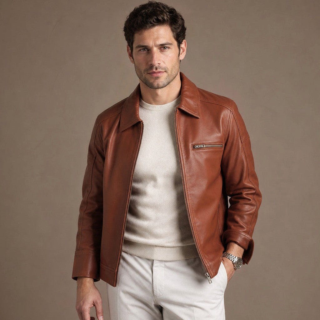Man wearing a tan sheepskin biker jacket over a knit with dark denim