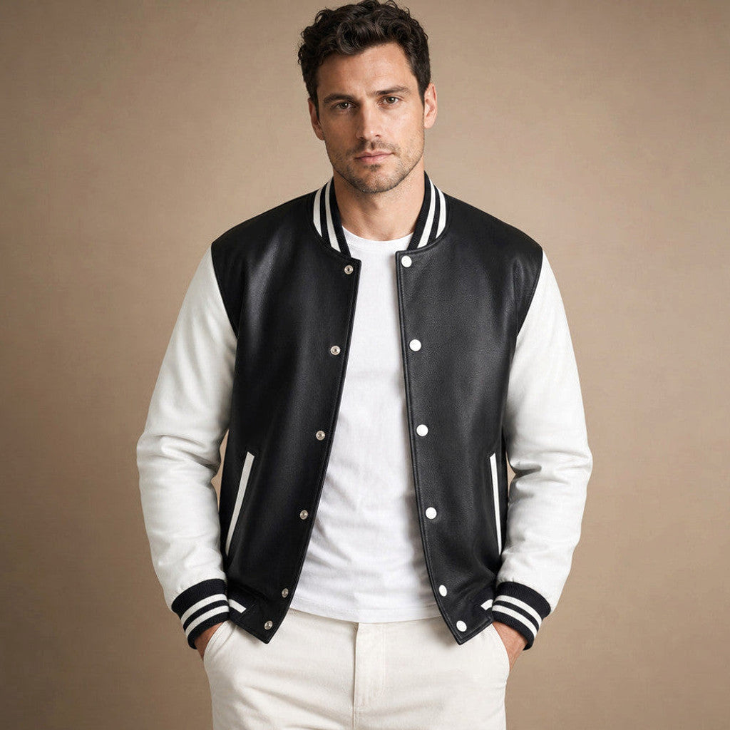 Man wearing a black varsity jacket with leather sleeves over a crewneck