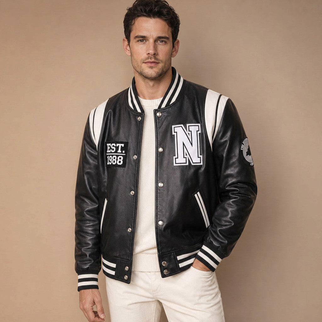 Man wearing a black and white sheepskin varsity jacket over a plain tee