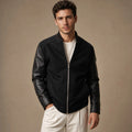 Man wearing a black leather-sleeve bomber jacket with ribbed collar and hem