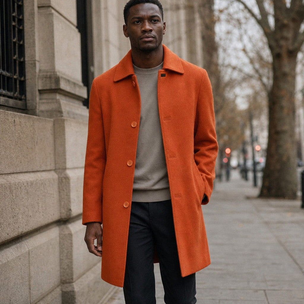 Man wearing a burnt orange wool car coat over a dark roll-neck