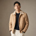 Man wearing beige suede trucker jacket with shearling collar and dark denim
